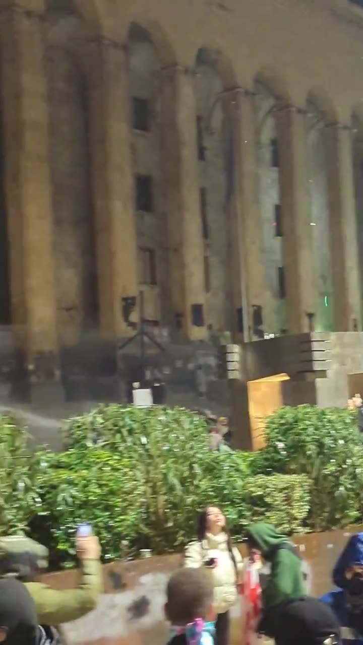 Riot police again pouring streams of water at protesters from inside the parliament. Water cannons also mobilized, and protesters occasionally fire fireworks at the parliament