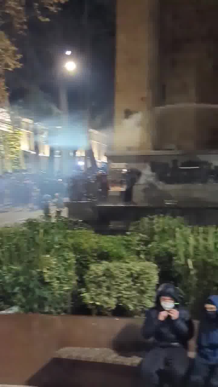 Riot police again pouring streams of water at protesters from inside the parliament. Water cannons also mobilized, and protesters occasionally fire fireworks at the parliament