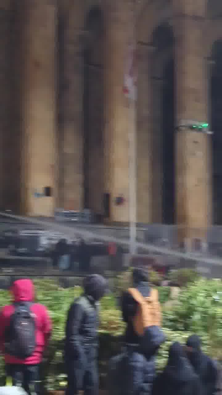 Riot police again pouring streams of water at protesters from inside the parliament. Water cannons also mobilized, and protesters occasionally fire fireworks at the parliament